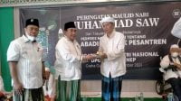 Ketua DPC PKB Sumenep, KH. Imam Hasyim memberikan potongan tumpeng kepada Ketua Dewan Syuro, KH. Nasikh Fauzi.