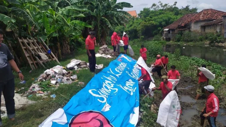 Kader PDI Perjuangan Kabupaten Sumenep saat membersihkan sepanjang sungai Kali Marengan. (Dok. Ist.)