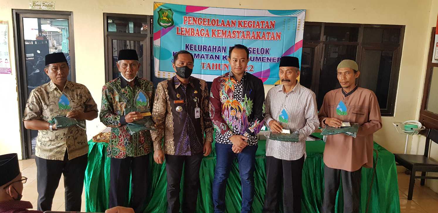 Camat Kota Sumenep, Faruk Hanafi, dan Lurah Bangselok, M Fajar Hidayat, saat foto bersama ketua RT yang raih penghargaan DLH Jatim.