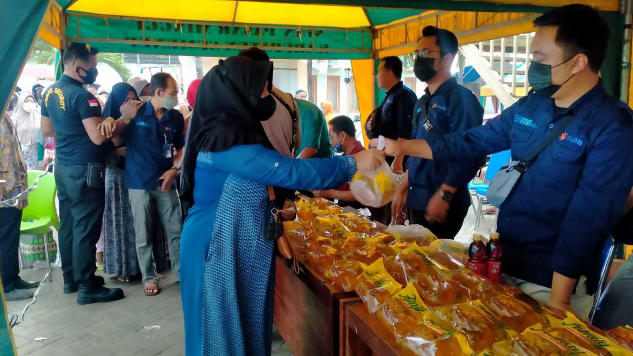 Salah seorang warga membeli minyak goreng di stand operasi pasar murah di Pasar Anom Baru Sumenep.