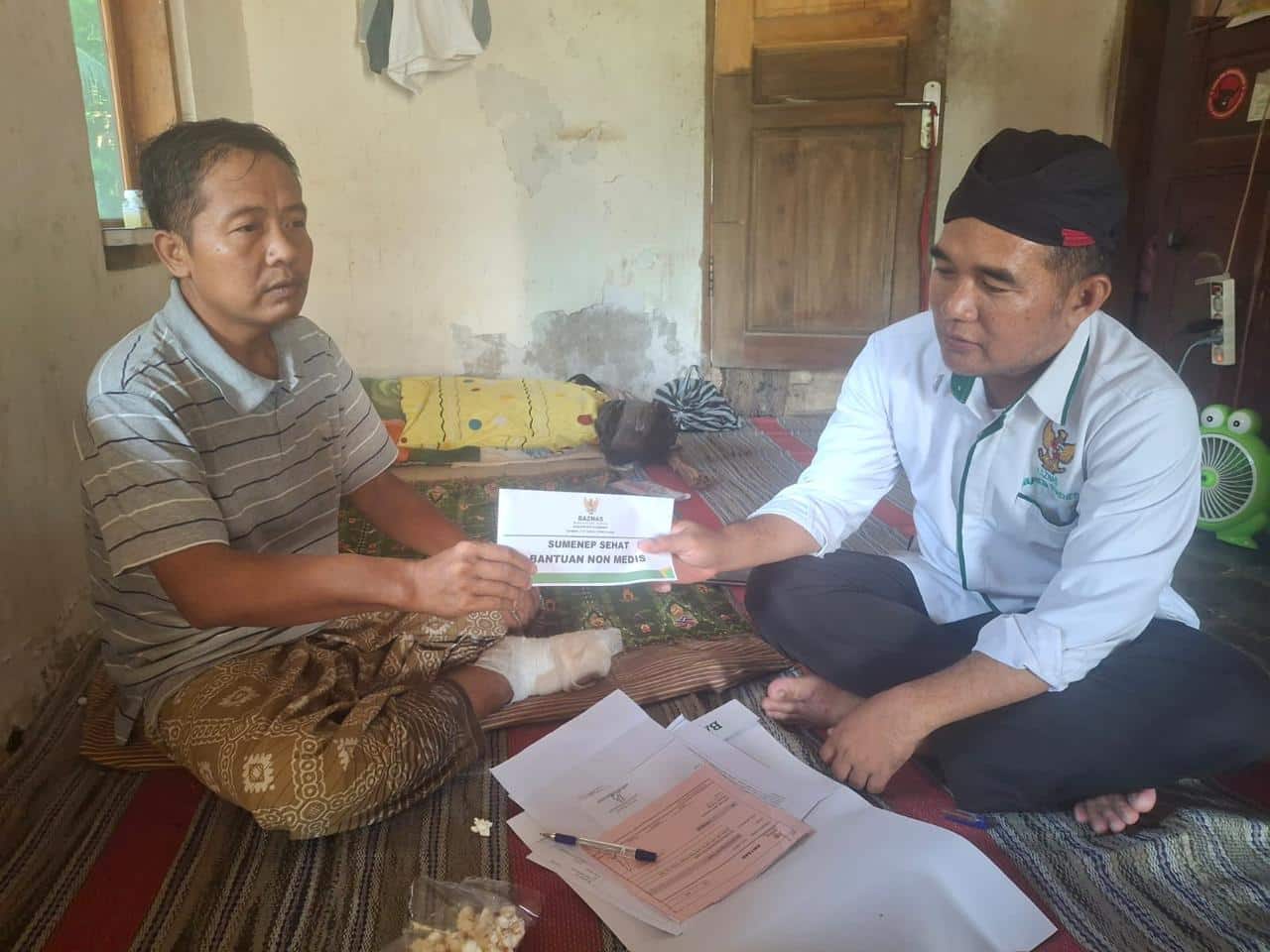 Ketua Baznas Sumenep, Ahmad Rahman saat menyalurkan bantuan Program “Sumenep Sehat” kepada warga kurang mampu.