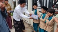Ketua DPC PWRI Sumenep, Rusydiyono, saat memberikan sarung kepada para santri.