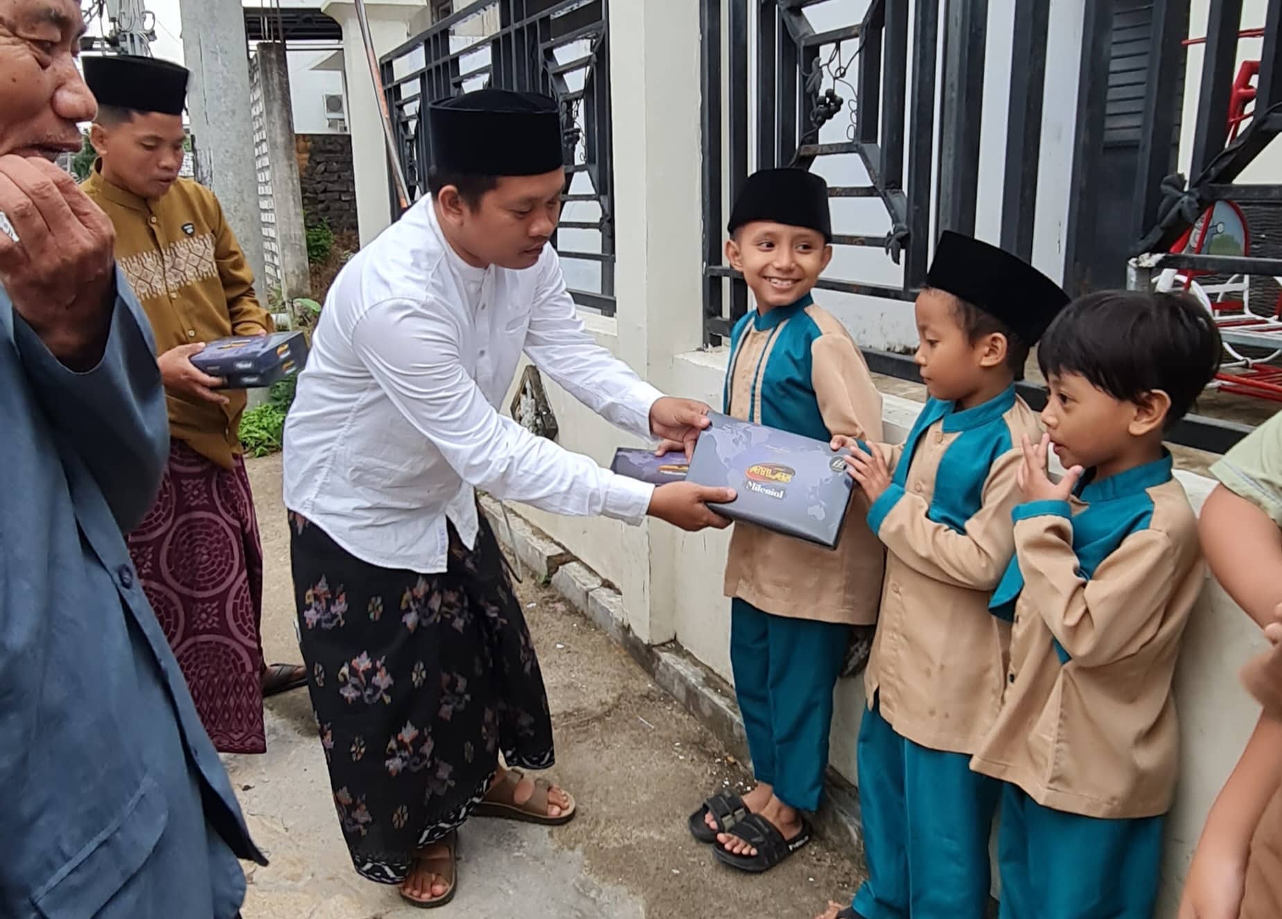 Ketua DPC PWRI Sumenep, Rusydiyono, saat memberikan sarung kepada para santri.