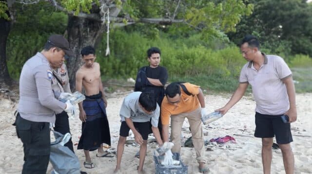 Foto : Polisi dan warga saat mengamankan barang diduga kokain di Giligenting.