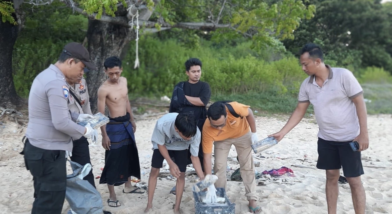 Foto : Polisi dan warga saat mengamankan barang diduga kokain di Giligenting.